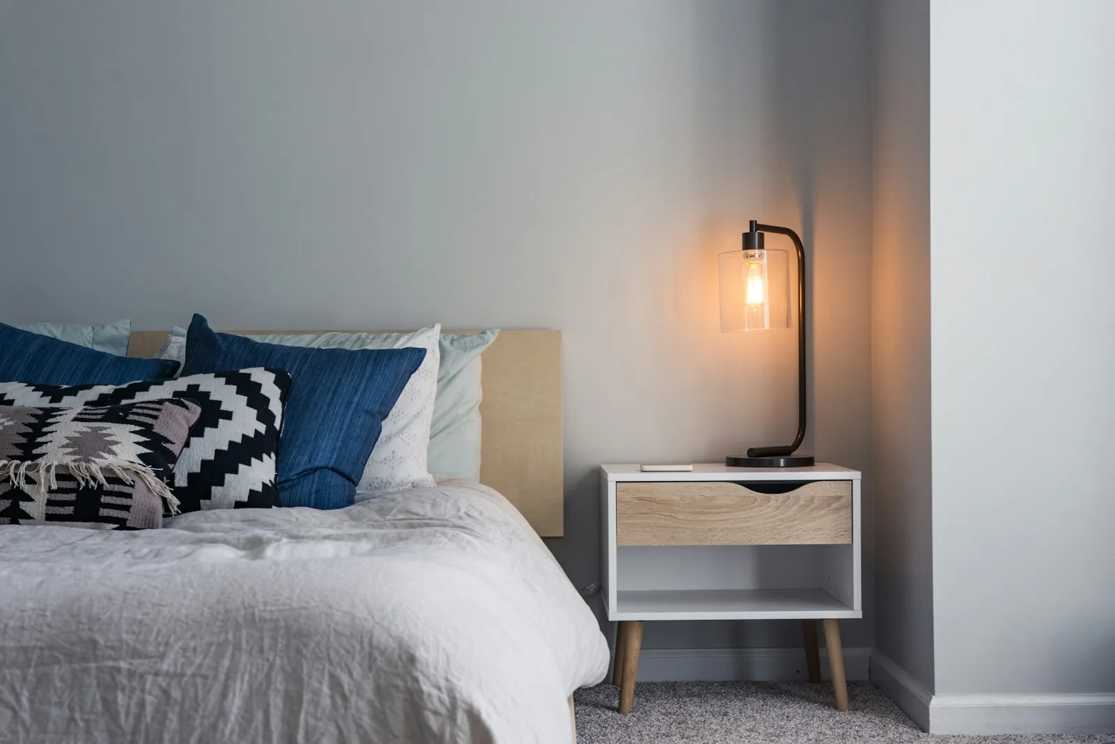 Table de nuit avec lampe à portée de main, au bord du lit
